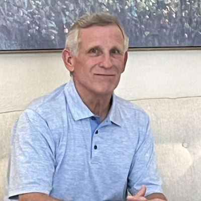 Chiropractor Houston TX Jerry Gholson Jerry Gholson, chiropractor at Dr. Karrie Yager Chiropractic in Houston, TX, wearing a blue shirt and sitting on a white sofa.